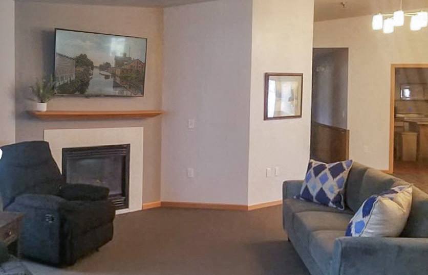 A living room with a grey couch and a fireplace.,A living room with a grey couch and a fireplace.